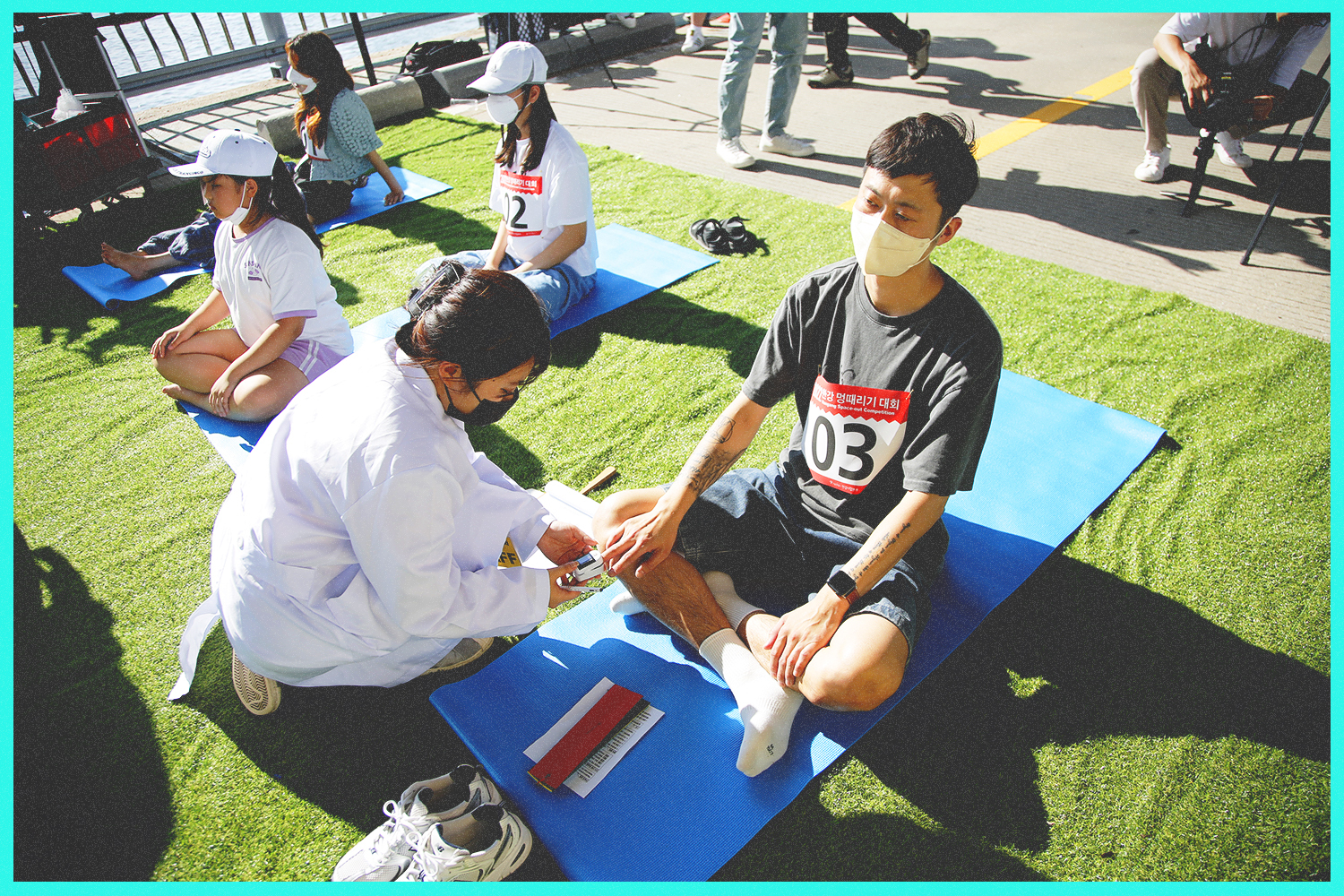 An attendant tracks the heart rate data of a competitor, clipping a monitor to his finger.