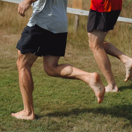 Two men running barefoot on turf. Here's why the natural ground is the best "exercise equipment."