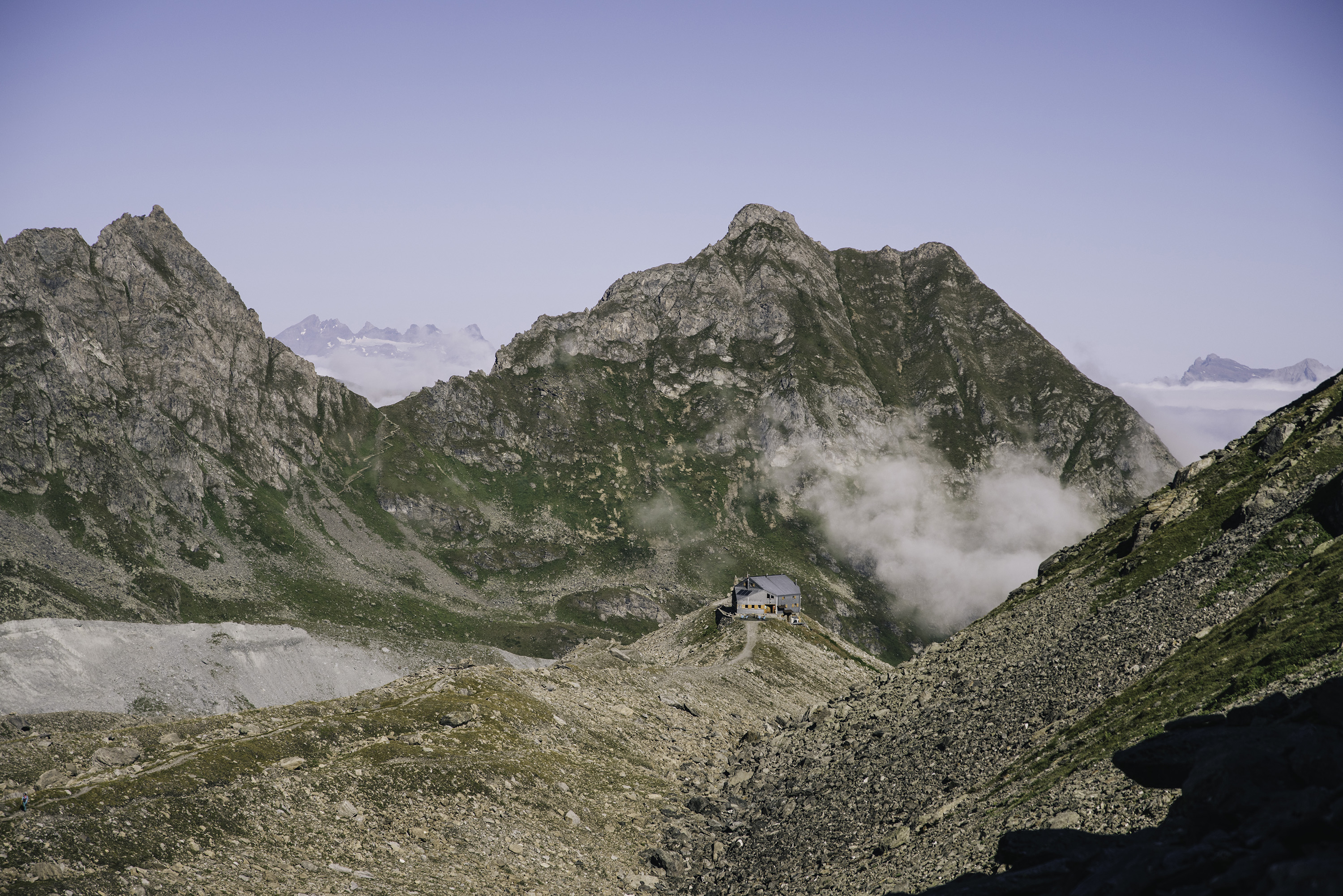 A dramatic aerial view of a Swiss cabin in the mountain.