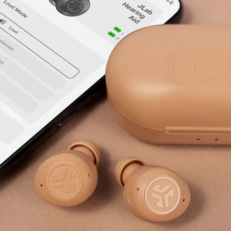 JLab HEAR earbuds in beige, next to a phone with the JLab app