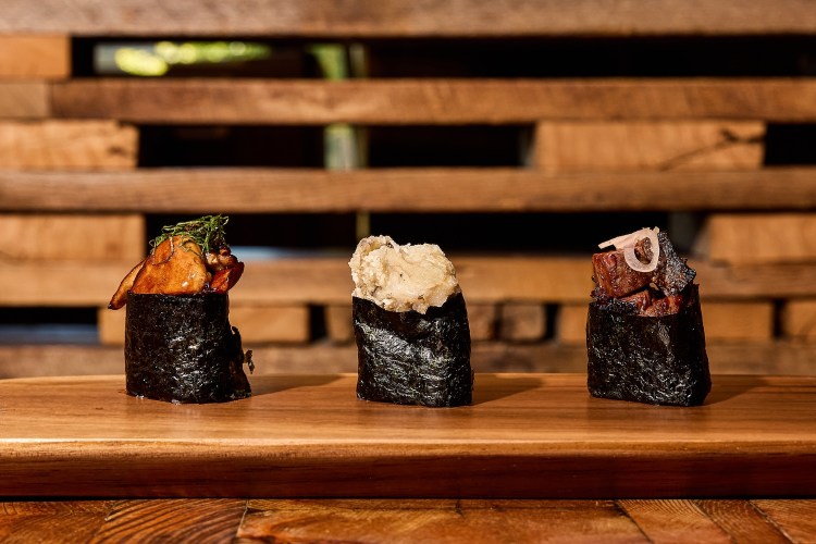 Three sushi rolls from Uchi plated and served next to each other