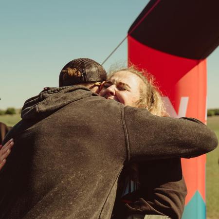 Nick Bare hugging a runner at the finish line.