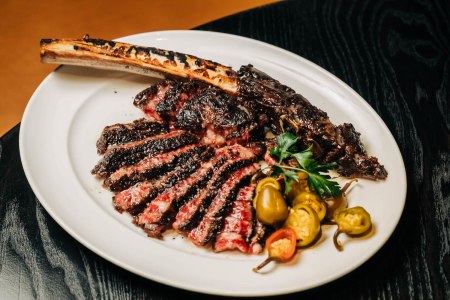 A tomahawk steak from RPM, garnished with jalapeño peppers.