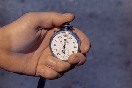 A man pressing an old-fashioned stopwatch.