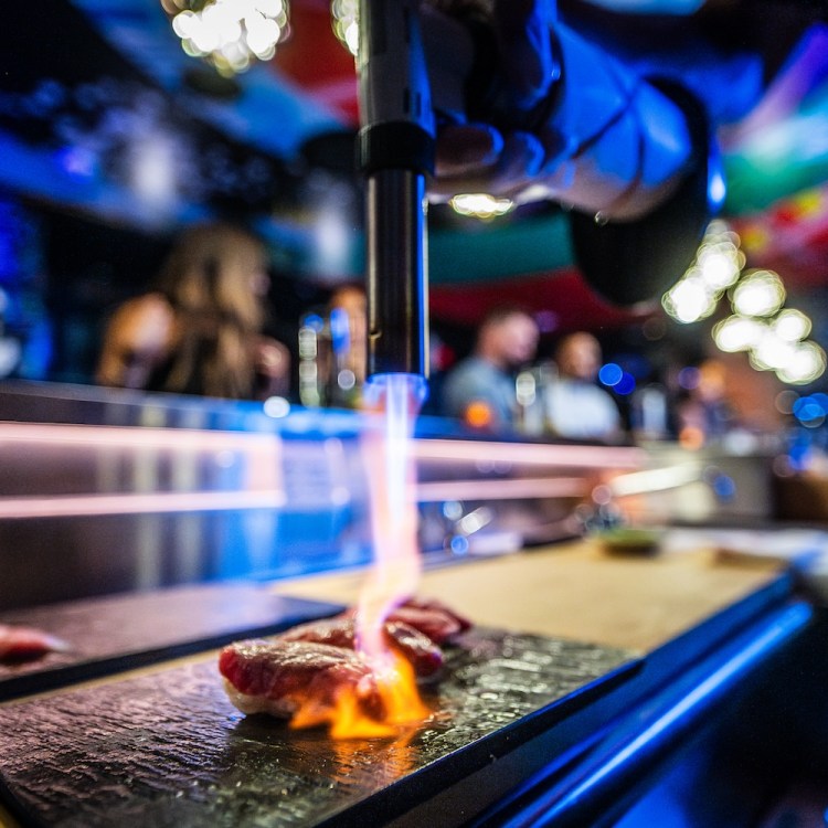 Close up of a piece of sushi under a flame