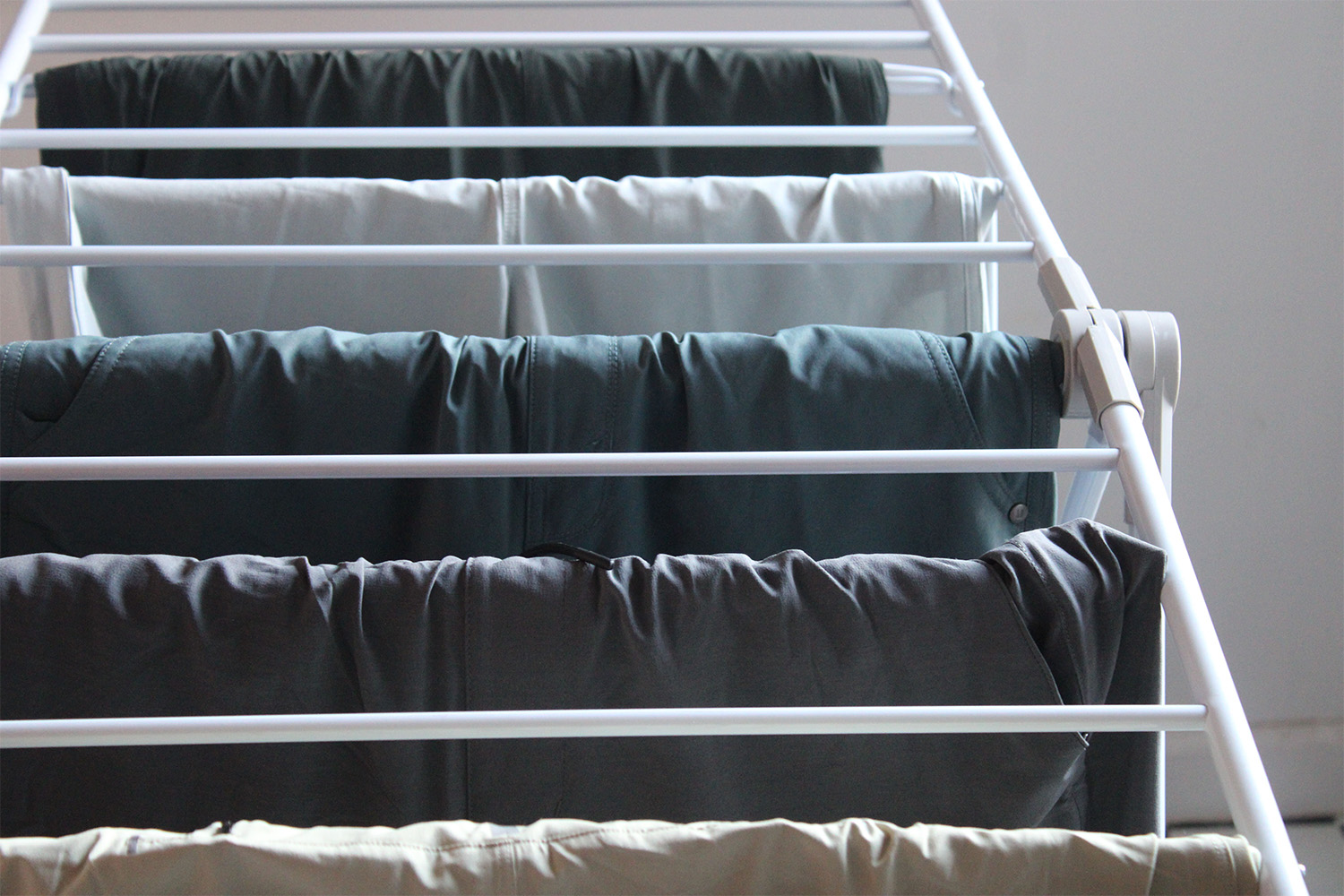 A variety of Vuori shorts hanging from a laundry rack.