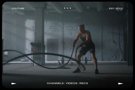 A man working out with battle ropes in an empty gym. We're taking a look at the best YouTube channels for fitness and wellness.