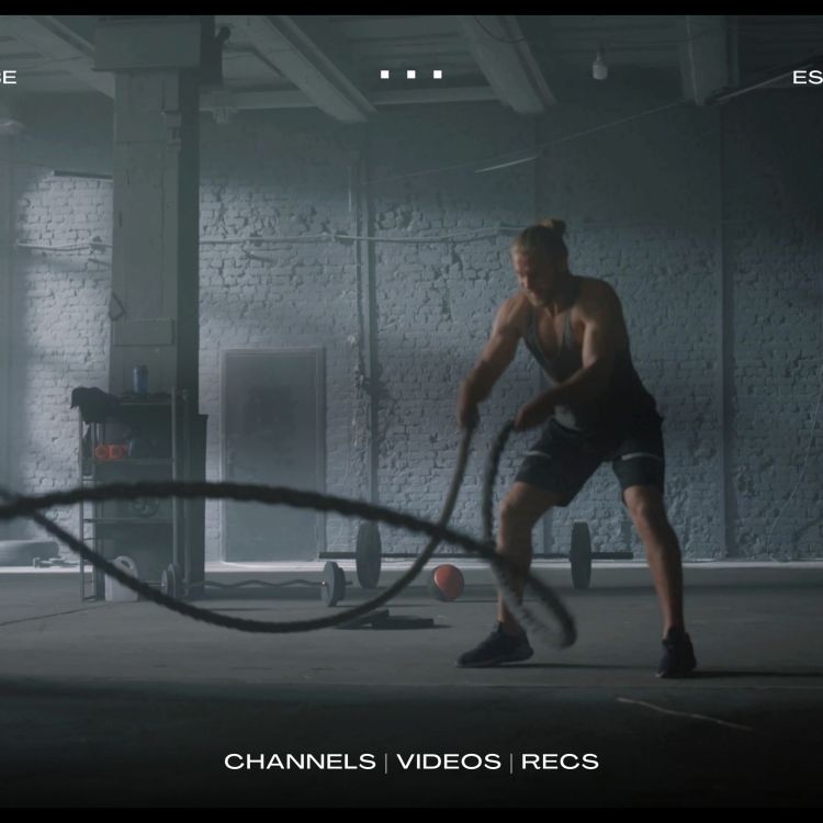 A man working out with battle ropes in an empty gym. We're taking a look at the best YouTube channels for fitness and wellness.