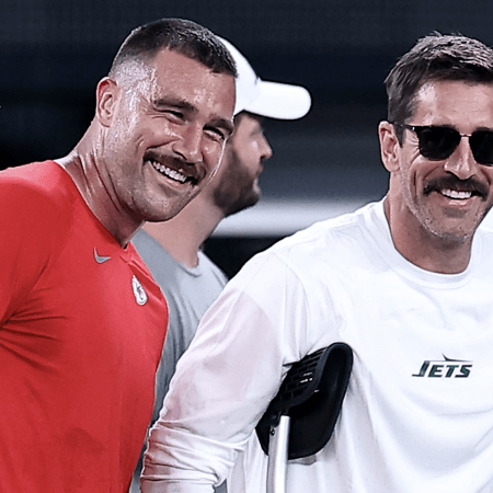 Travis Kelce talks with an injured Aaron Rodgers at MetLife Stadium.